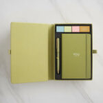 Home 90 Premium corporate stationery gift set in olive gold magnetic closure box revealing branded notebook pen and highlighters on white marble