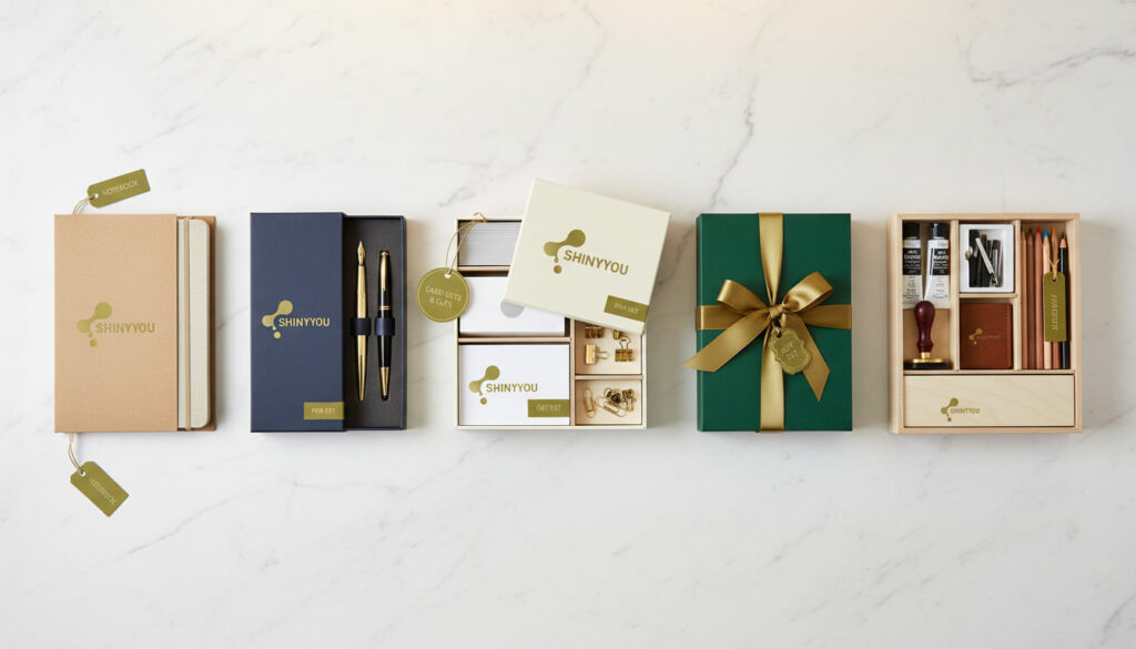 Branded stationery boxes for different products showing kraft slipcase pen set box card organizer gift box and art supply tray on white marble